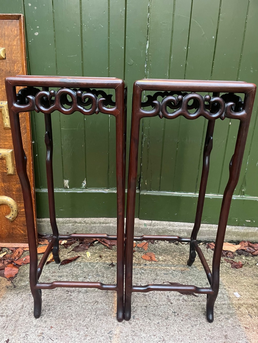 A pair of tall late 19th-century Chinese Qing Dynasty dark hardwood stands featuring square tops, openwork carved scroll aprons, and slender serpentine legs. View XVIII