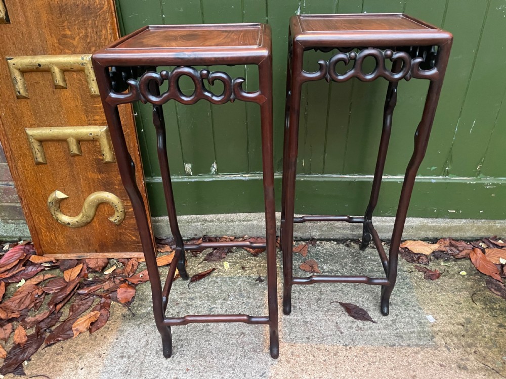 A pair of tall late 19th-century Chinese Qing Dynasty dark hardwood stands featuring square tops, openwork carved scroll aprons, and slender serpentine legs. View XXII