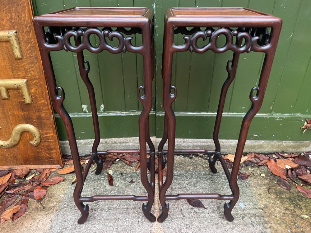 A pair of tall late 19th-century Chinese Qing Dynasty dark hardwood stands featuring square tops, openwork carved scroll aprons, and slender serpentine legs. View XXIII