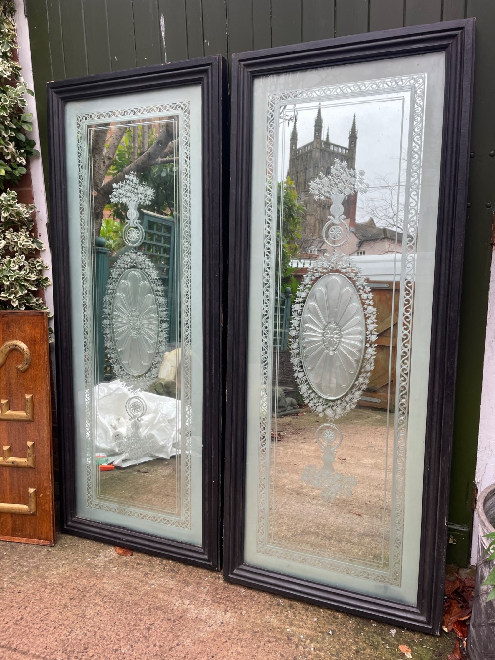 A pair of tall rectangular Edwardian wall mirrors featuring detailed etched floral urns and central oval medallions in dark wooden frames. View VII