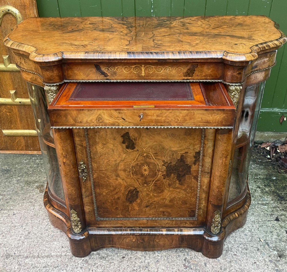 A mid-19th century Victorian burr walnut credenza featuring boxwood marquetry inlay, gilded ormolu mounts, a central drawer, and curved glass side display doors. View VIII