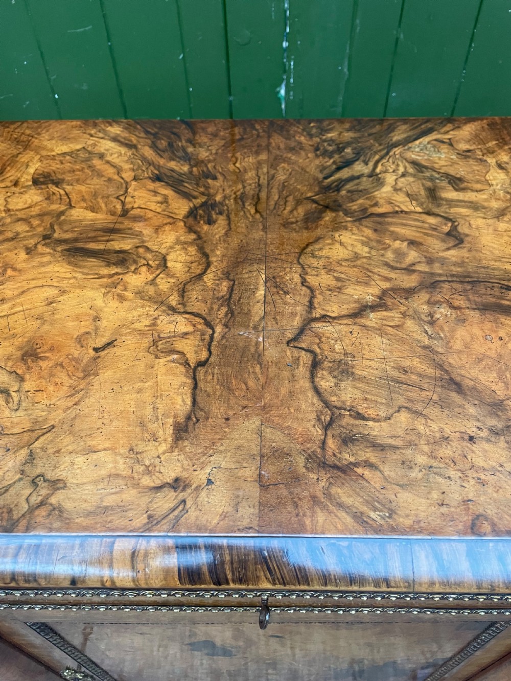 A mid-19th century Victorian burr walnut credenza featuring boxwood marquetry inlay, gilded ormolu mounts, a central drawer, and curved glass side display doors. View XXI