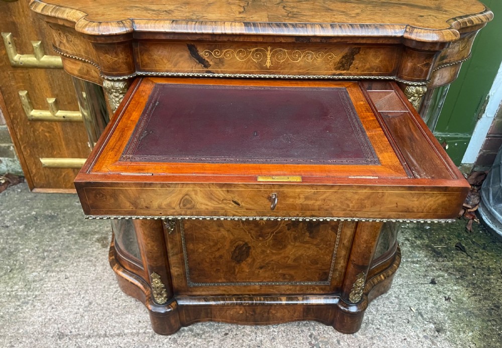 A mid-19th century Victorian burr walnut credenza featuring boxwood marquetry inlay, gilded ormolu mounts, a central drawer, and curved glass side display doors. View XXIII
