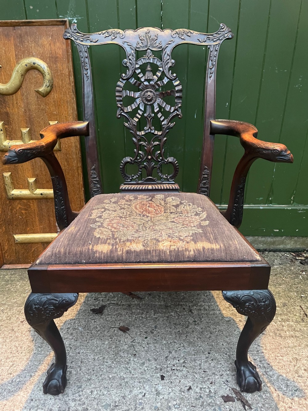 A late 19th-century carved mahogany armchair featuring carved eagle-head armrests, a pierced ribbon splat back, floral tapestry upholstery, and cabriole legs with claw-and-ball feet.