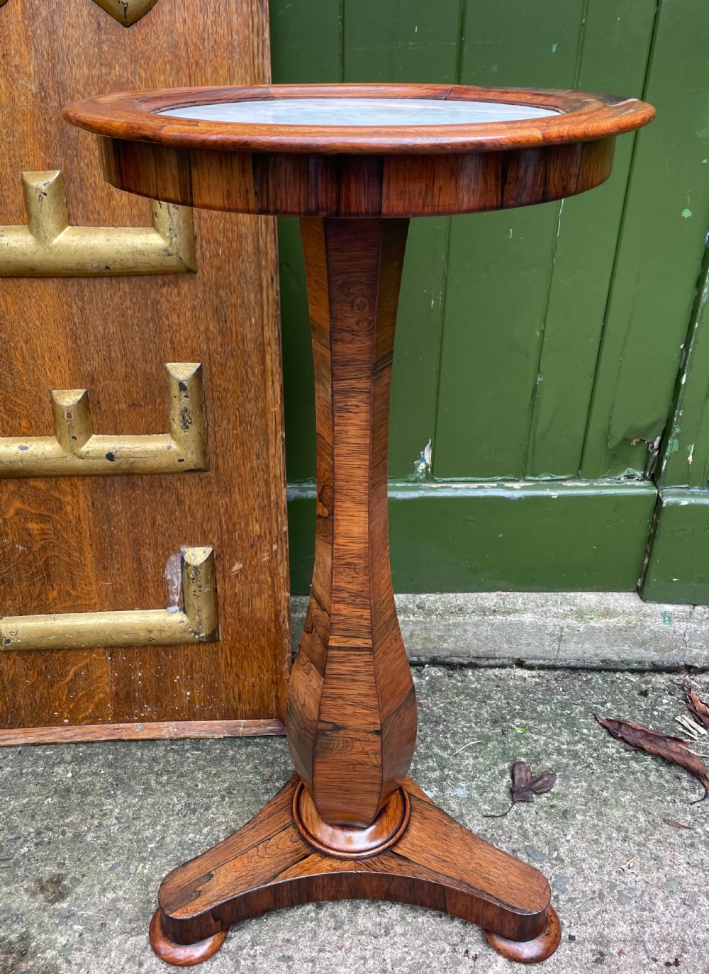 An early 19th-century George IV occasional table featuring a circular top with an inset marble panel, a faceted rosewood column, and a triform base.