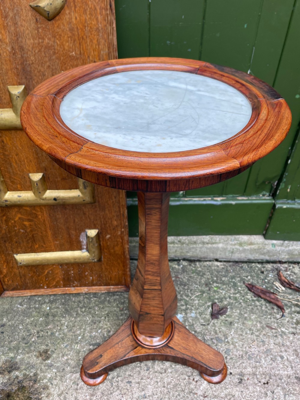 An early 19th-century George IV occasional table featuring a circular top with an inset marble panel, a faceted rosewood column, and a triform base. View II