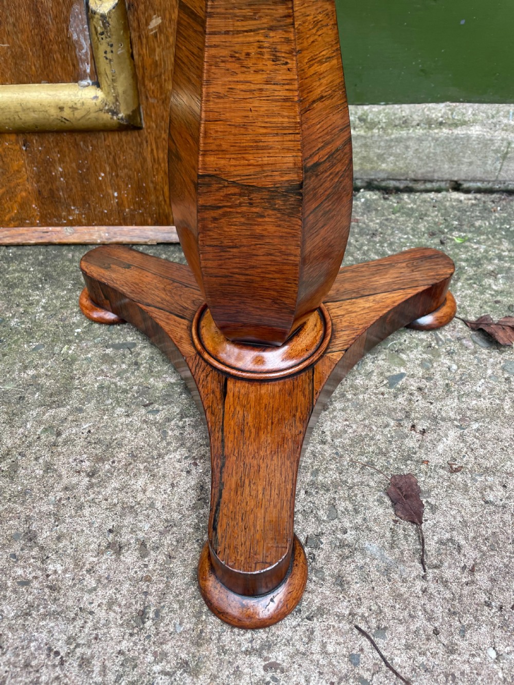 An early 19th-century George IV occasional table featuring a circular top with an inset marble panel, a faceted rosewood column, and a triform base. View III