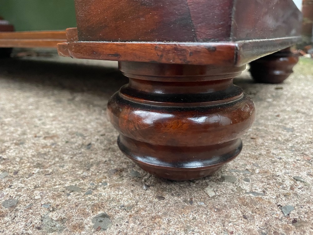 An early nineteenth-century mahogany serpentine side table featuring two drawers, a gallery top, curved end supports, and a lower shelf. View XVII