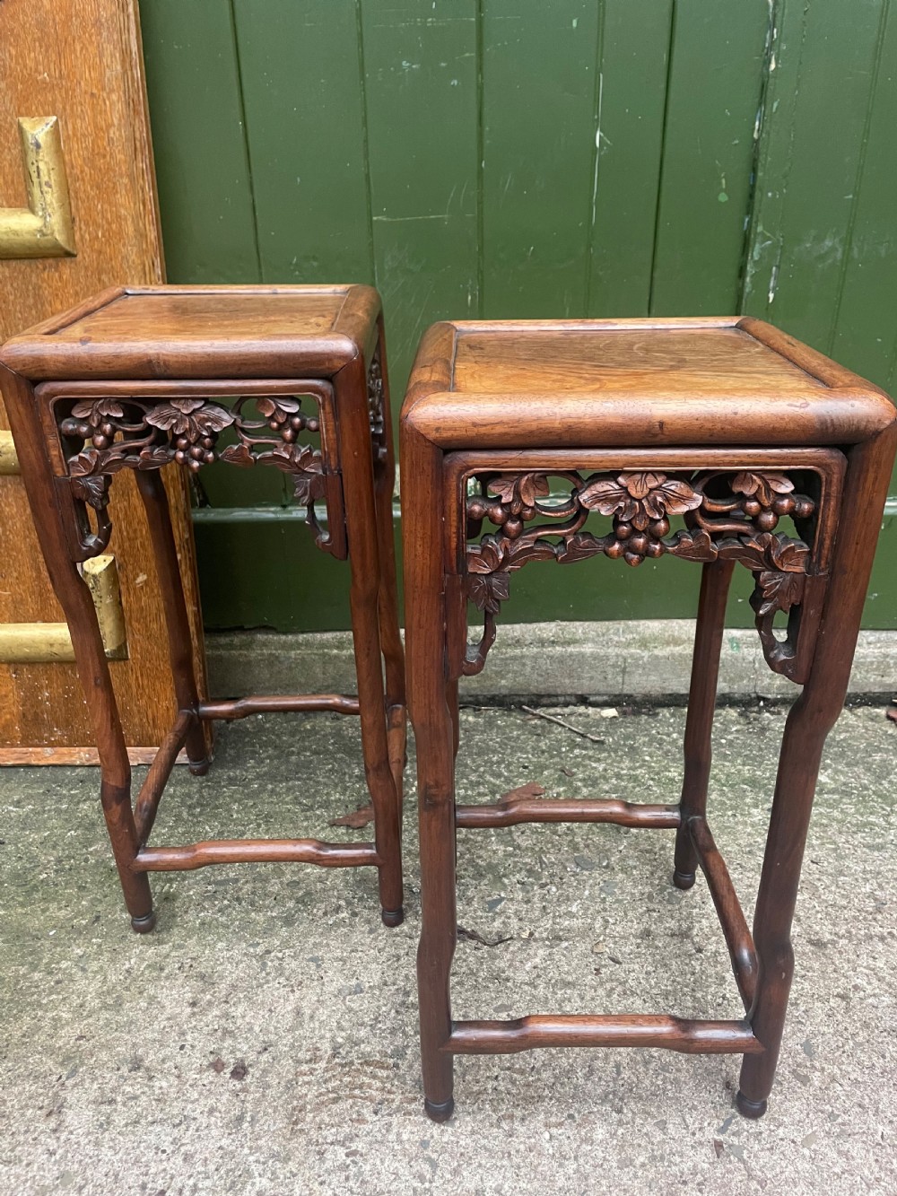 A pair of late nineteenth to early twentieth century Chinese Qing Dynasty carved huali hardwood side tables featuring openwork grapevine aprons and organic faux-bamboo legs. View II
