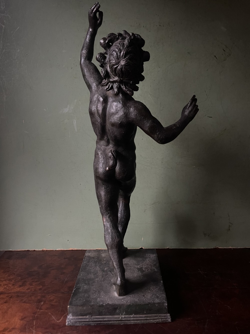A late nineteenth-century dark patinated bronze sculpture depicting the Dancing Faun of Pompeii standing in a dynamic pose on a rectangular bronze base. View V
