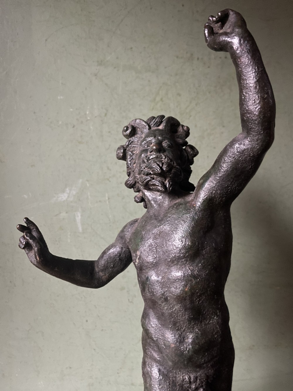 A late nineteenth-century dark patinated bronze sculpture depicting the Dancing Faun of Pompeii standing in a dynamic pose on a rectangular bronze base. View XI