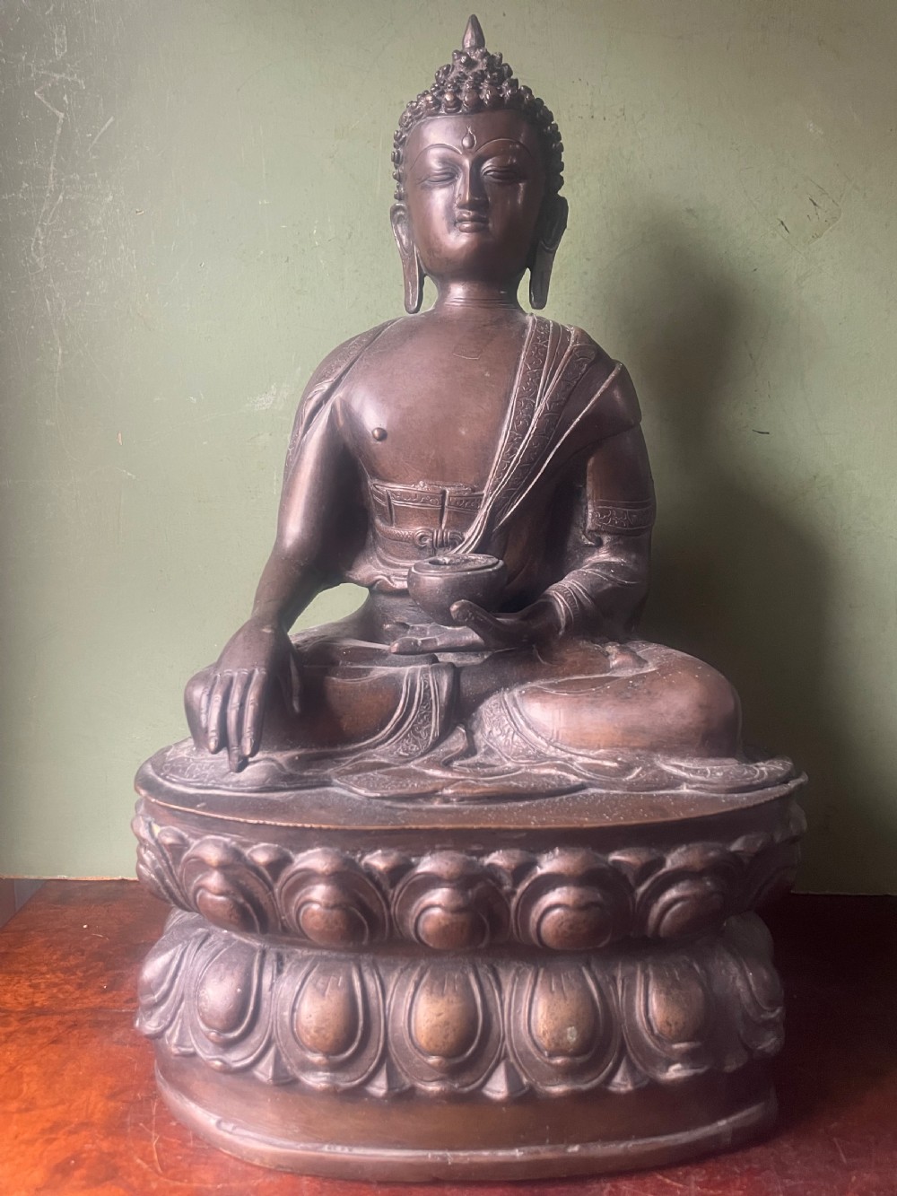 A 19th-century Sino-Tibetan style dark bronze sculpture of Buddha Shakyamuni seated on a lotus pedestal.