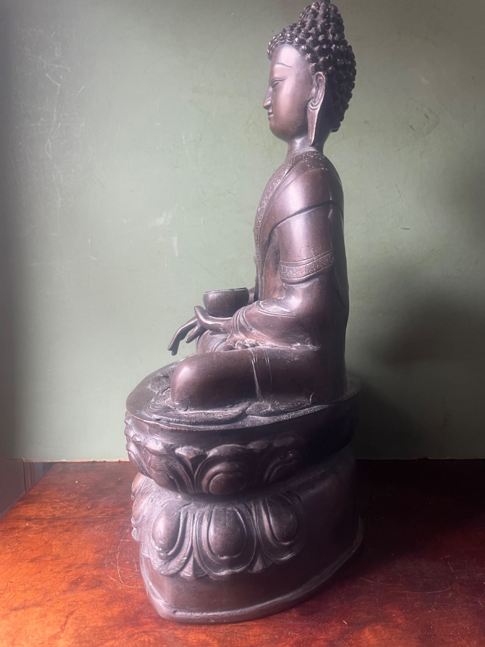 A 19th-century Sino-Tibetan style dark bronze sculpture of Buddha Shakyamuni seated on a lotus pedestal. View III