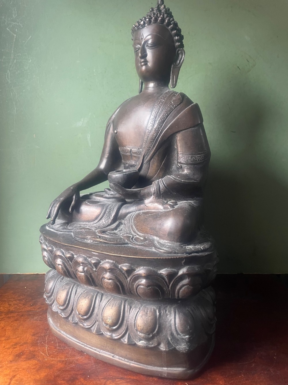 A 19th-century Sino-Tibetan style dark bronze sculpture of Buddha Shakyamuni seated on a lotus pedestal. View V