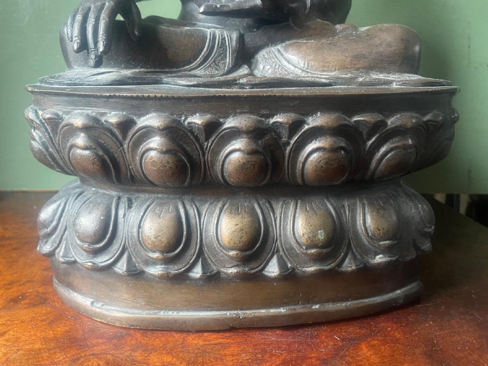 A 19th-century Sino-Tibetan style dark bronze sculpture of Buddha Shakyamuni seated on a lotus pedestal. View IX