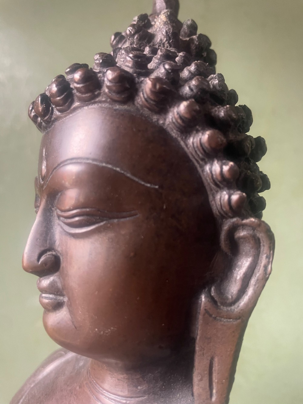 A 19th-century Sino-Tibetan style dark bronze sculpture of Buddha Shakyamuni seated on a lotus pedestal. View X