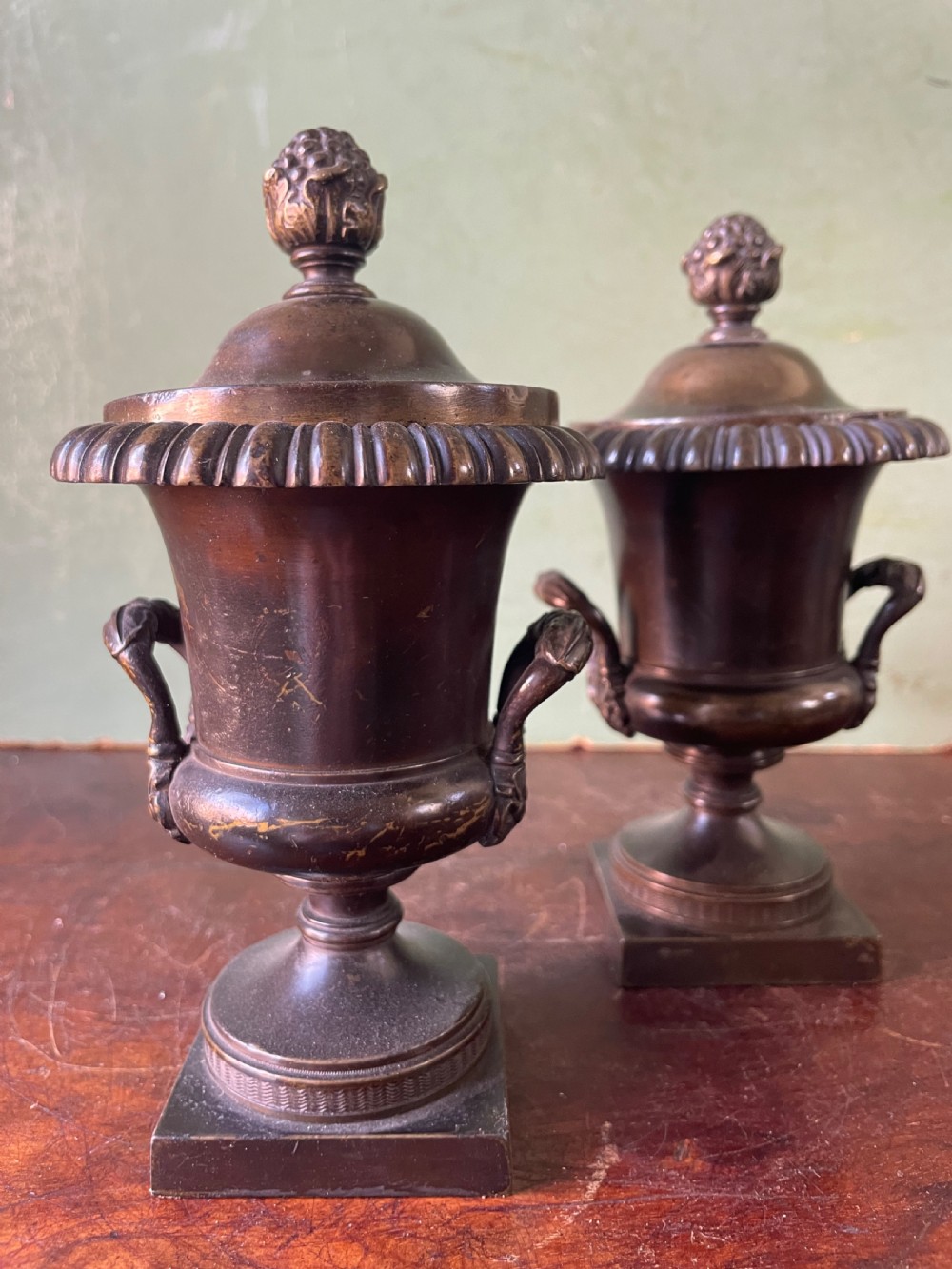 A pair of early nineteenth-century Regency dark brown bronze cassolettes with campana-shaped bodies, double loop handles, gadrooned lids topped with finials, resting on square plinth bases. View III