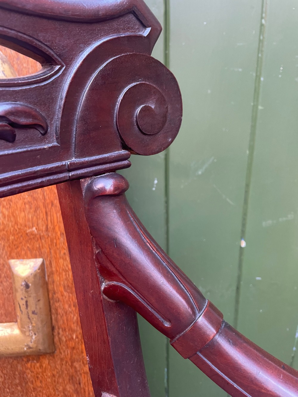 A pair of early 19th-century carved mahogany salon armchairs featuring carved crest rails, scrolled armrests, turned front legs, and blue striped fabric upholstery. View XXVI