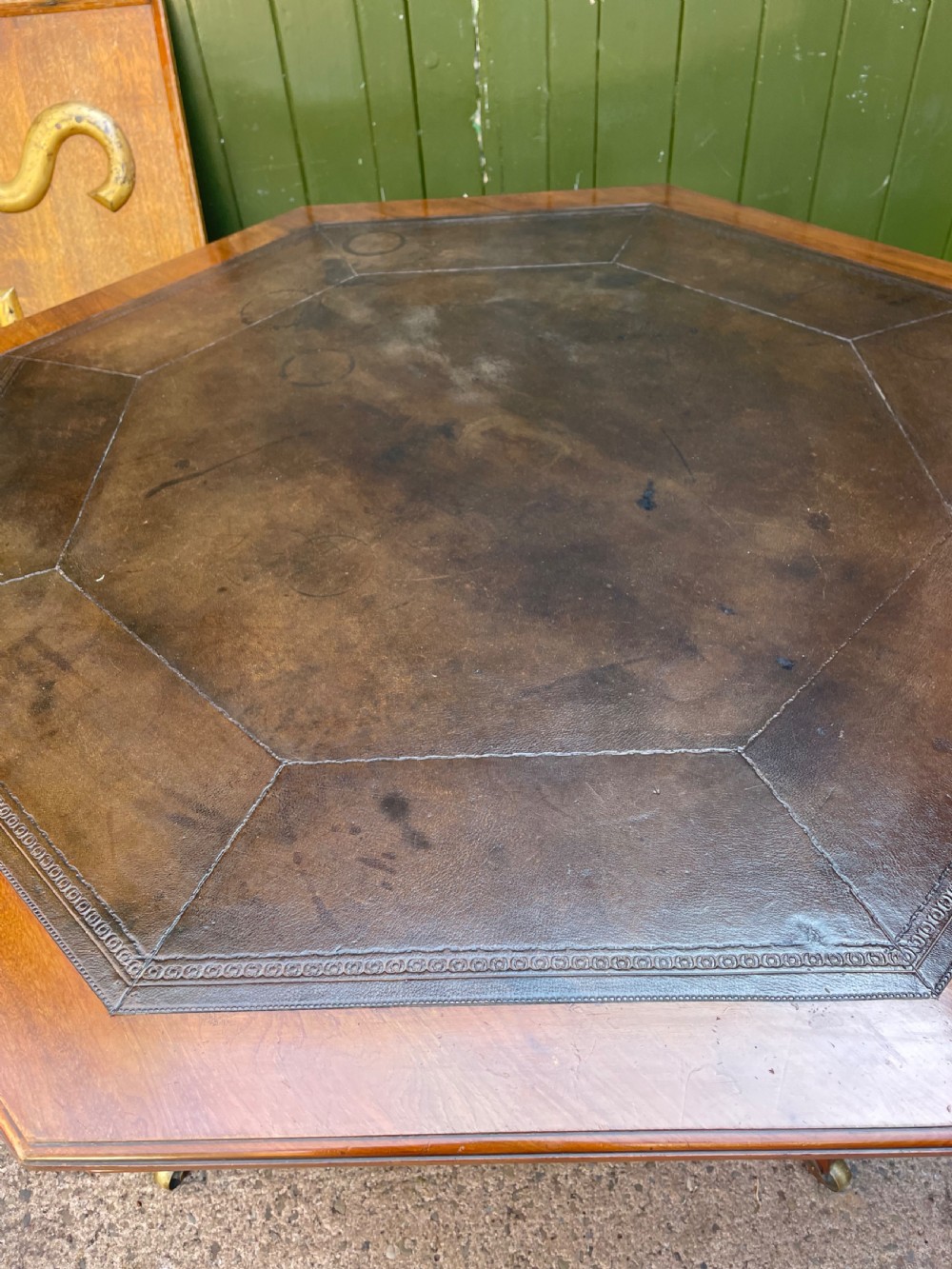 A late nineteenth-century octagonal walnut library table featuring a tooled dark leather inset top, turned legs, a cross stretcher, and brass castors. View III