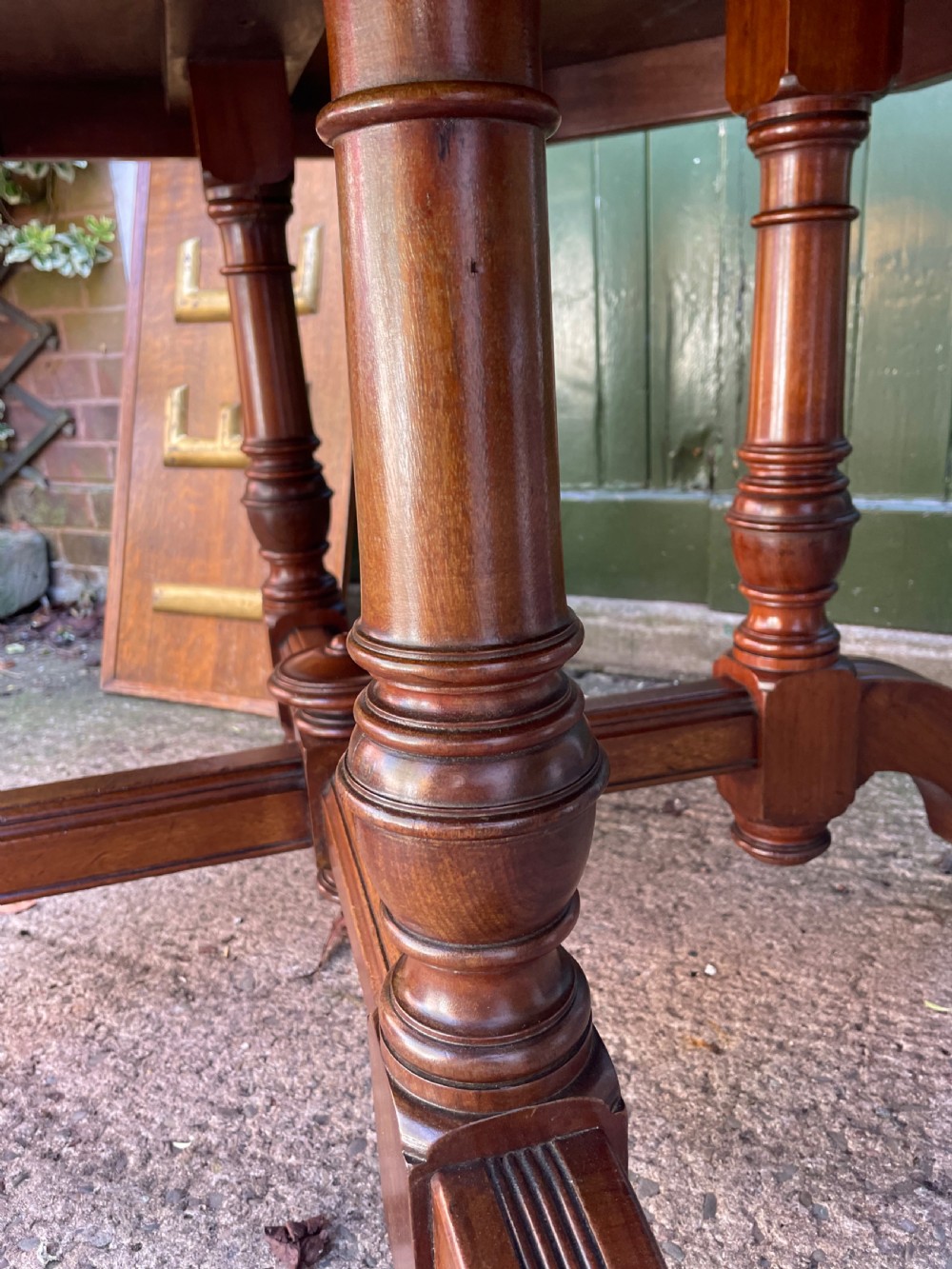 A late nineteenth-century octagonal walnut library table featuring a tooled dark leather inset top, turned legs, a cross stretcher, and brass castors. View X