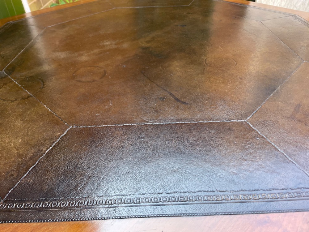 A late nineteenth-century octagonal walnut library table featuring a tooled dark leather inset top, turned legs, a cross stretcher, and brass castors. View XII