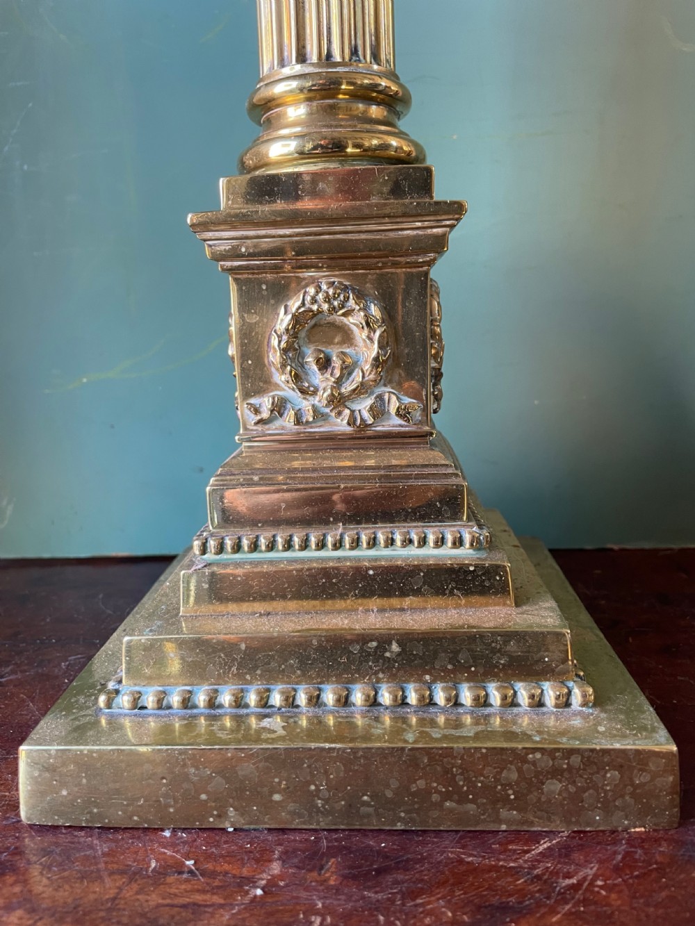 A late 19th-century brass table lamp styled as a classical fluted column with a stepped base and laurel wreath detail. View VI