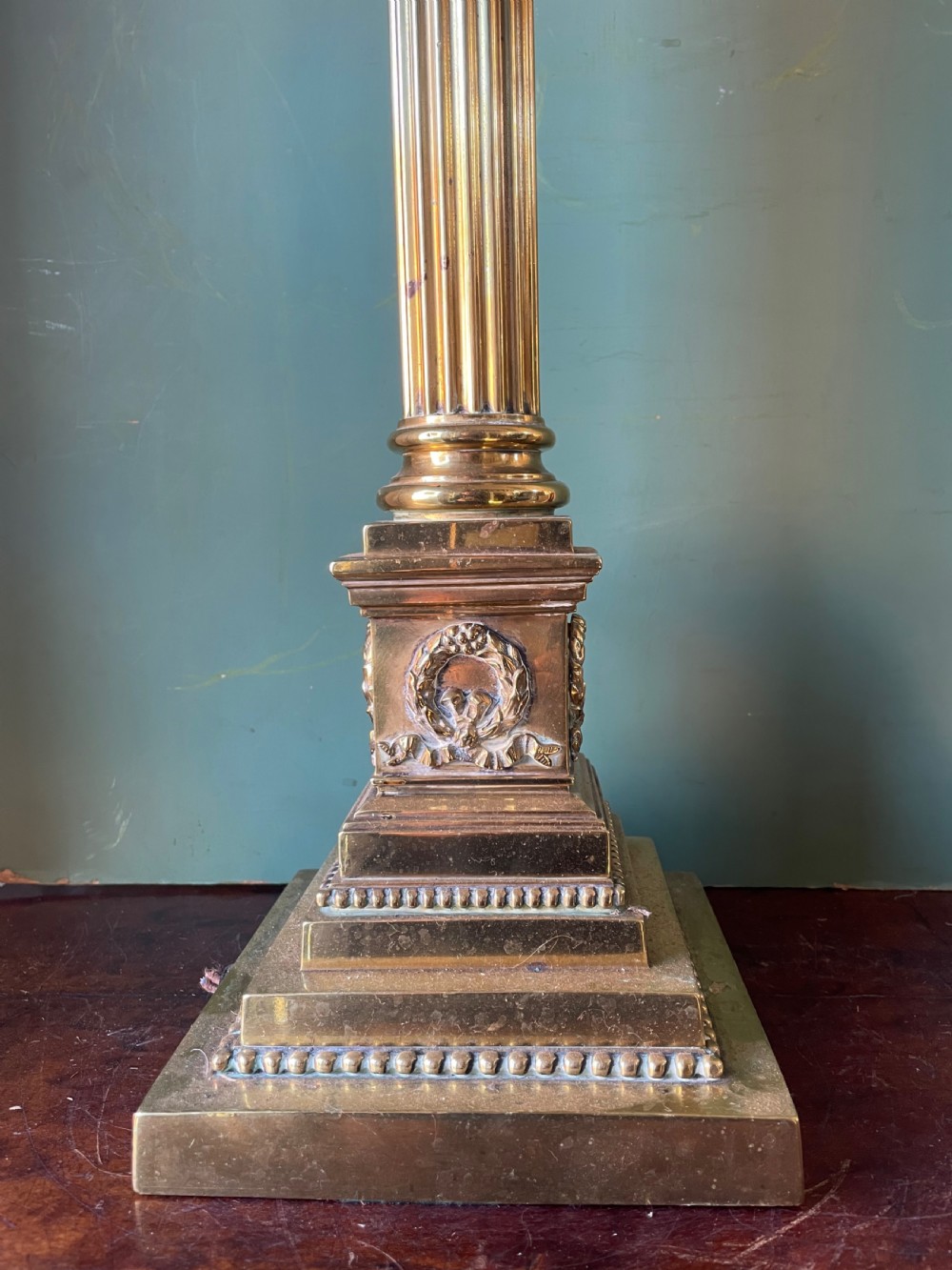 A late 19th-century brass table lamp styled as a classical fluted column with a stepped base and laurel wreath detail. View IX