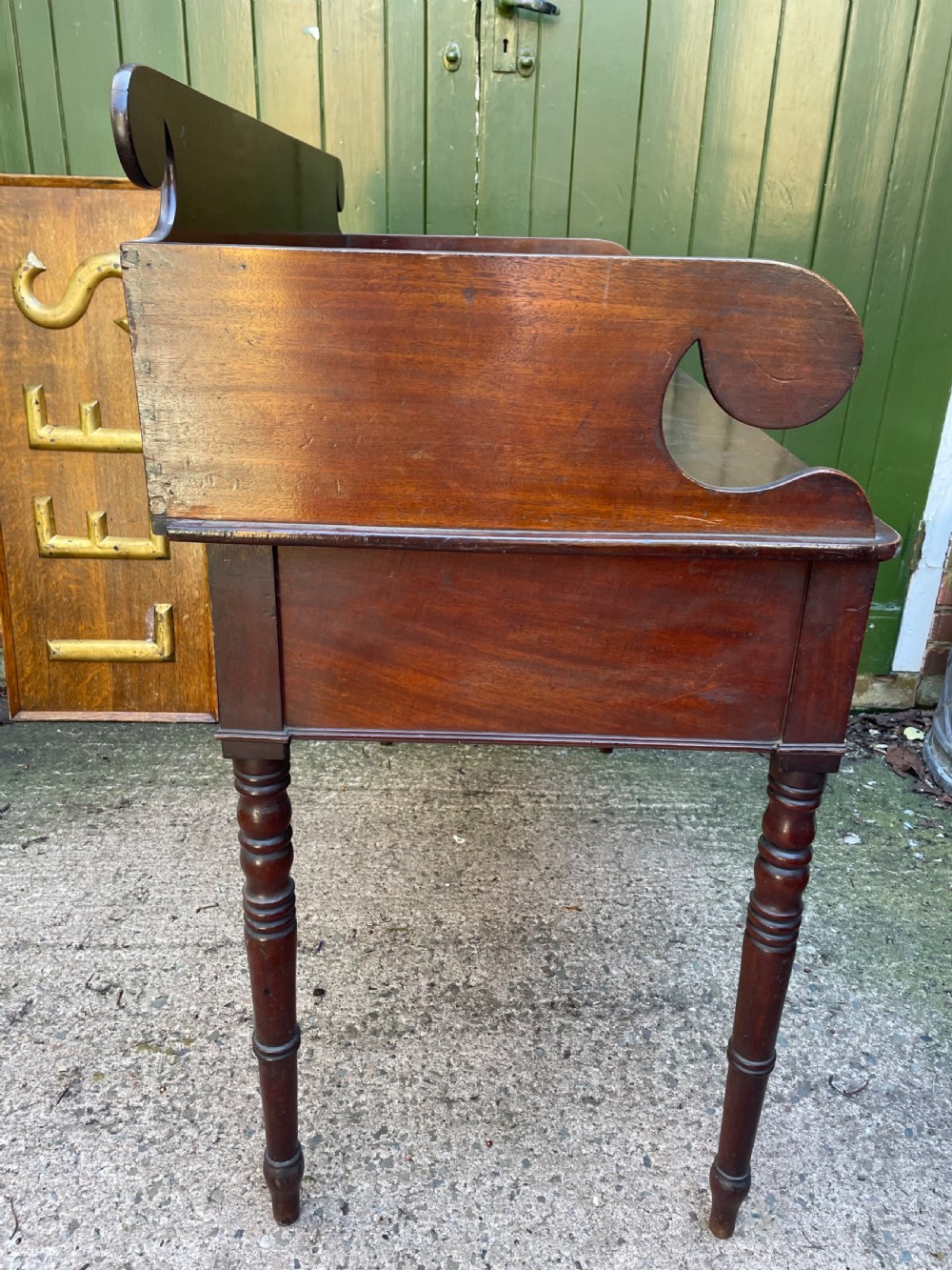 An early 19th-century George III mahogany kneehole dressing table with a scroll-ended three-quarter gallery back, multiple drawers, and ring-turned legs. View VII