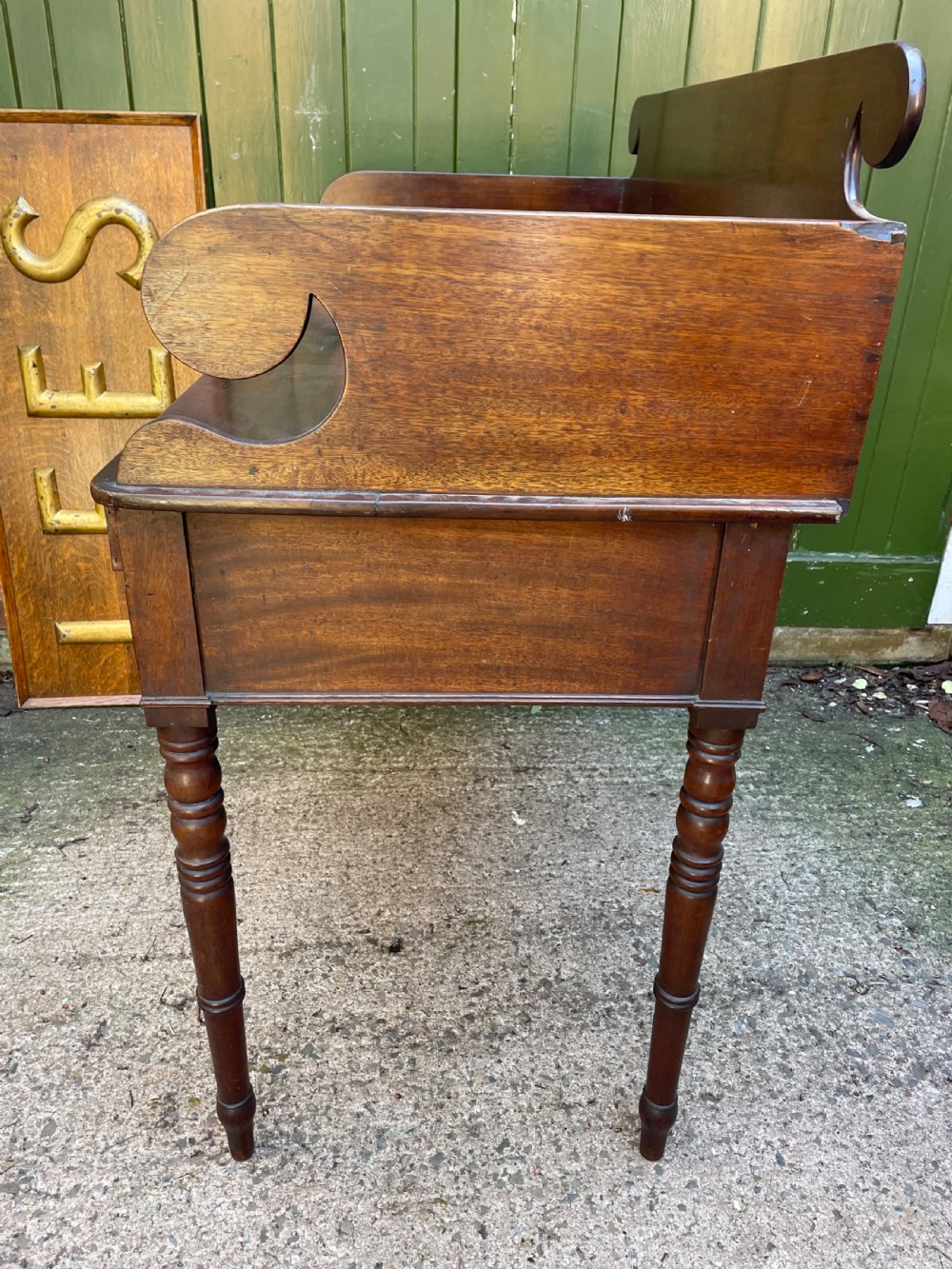An early 19th-century George III mahogany kneehole dressing table with a scroll-ended three-quarter gallery back, multiple drawers, and ring-turned legs. View XI