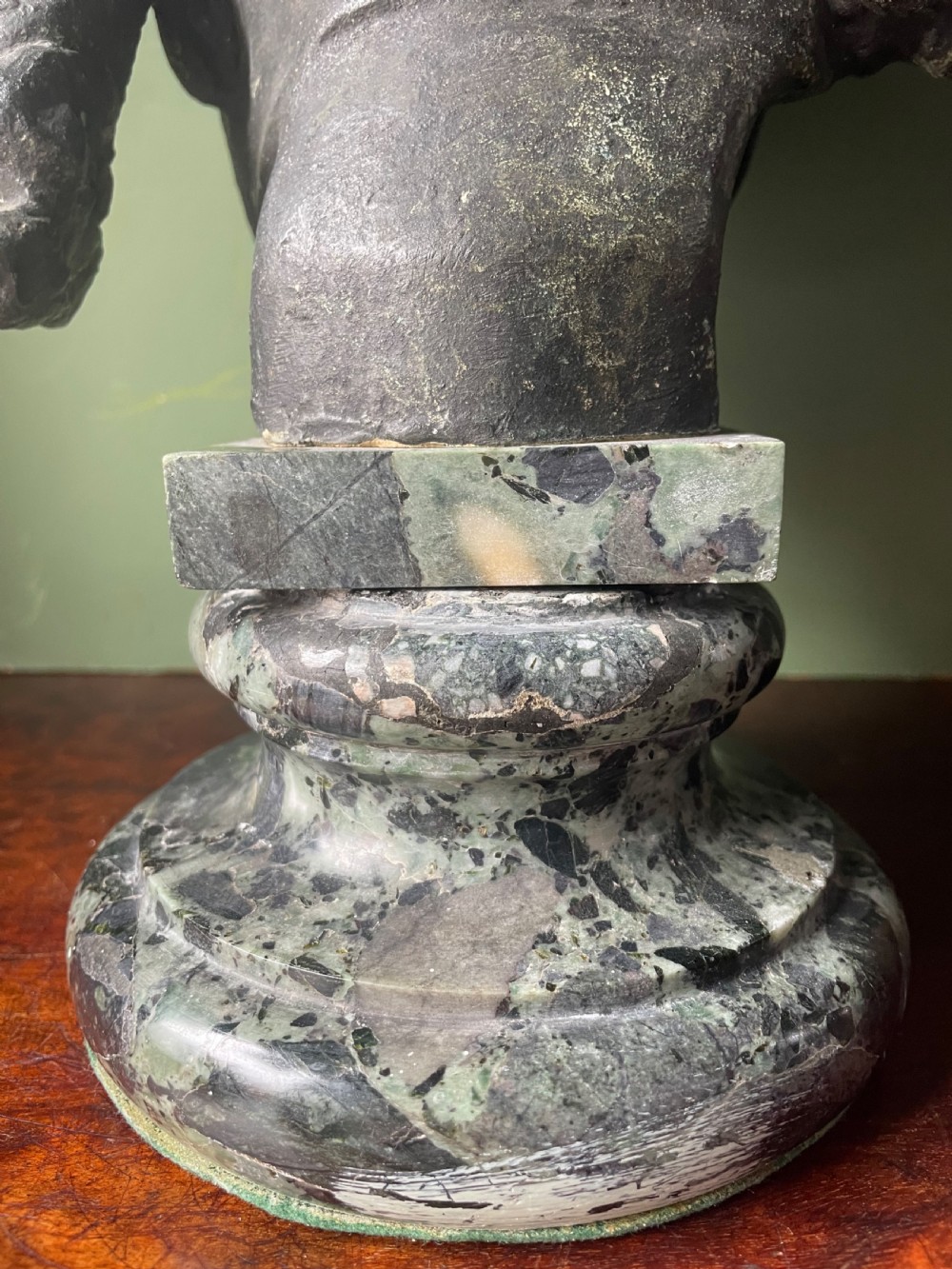 A 19th-century verdigris bronze head study of Hypnos featuring a winged temple, mounted on a round variegated green marble base. View VII