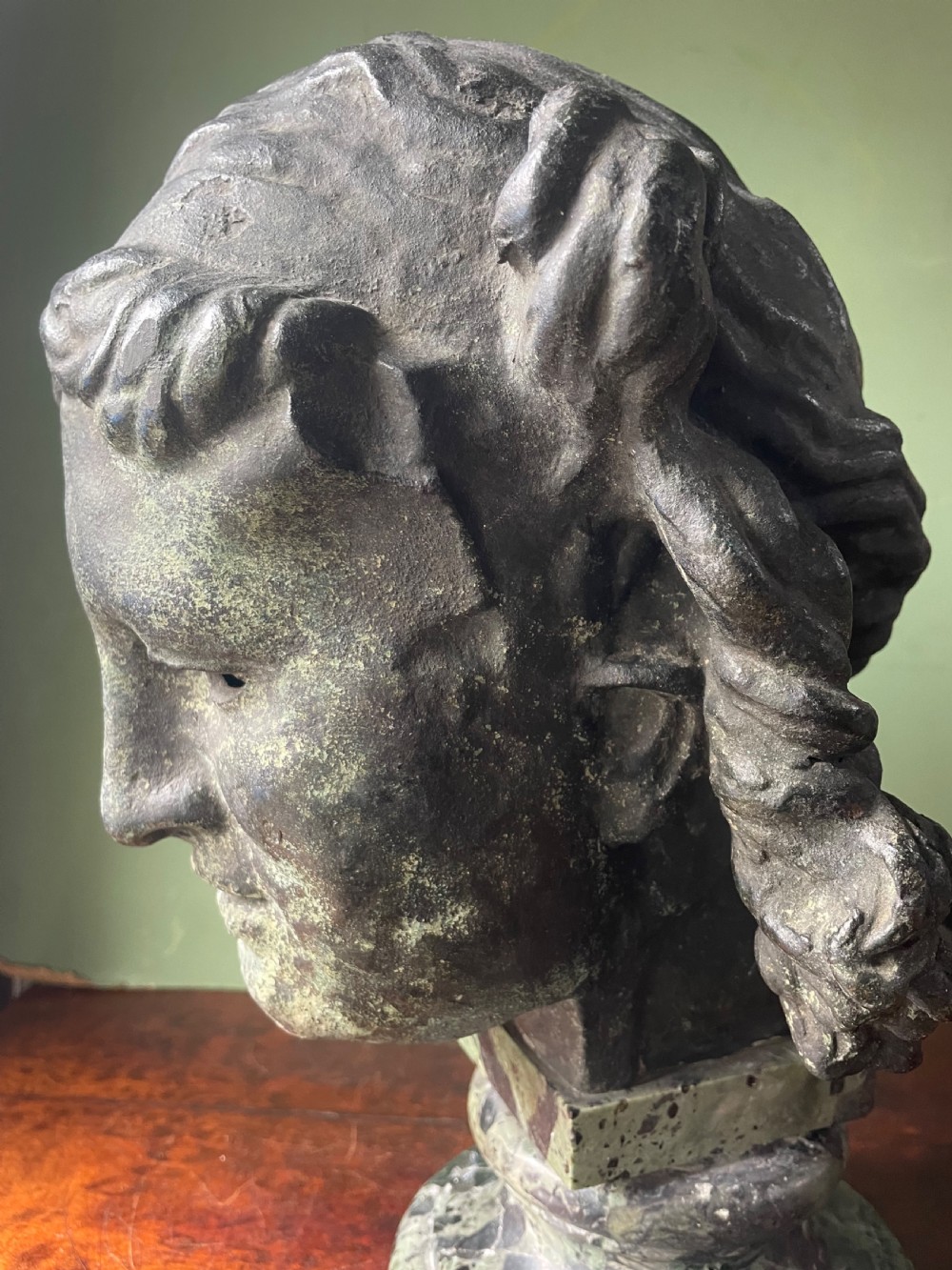 A 19th-century verdigris bronze head study of Hypnos featuring a winged temple, mounted on a round variegated green marble base. View XIV