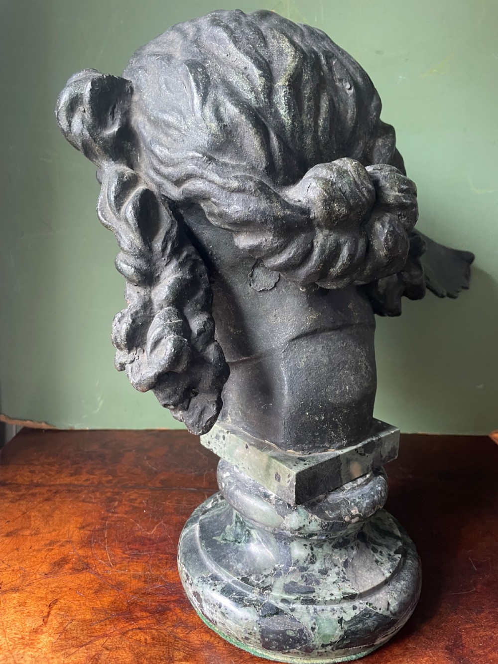 A 19th-century verdigris bronze head study of Hypnos featuring a winged temple, mounted on a round variegated green marble base. View XV