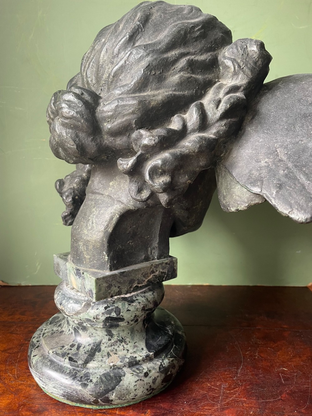 A 19th-century verdigris bronze head study of Hypnos featuring a winged temple, mounted on a round variegated green marble base. View XIX