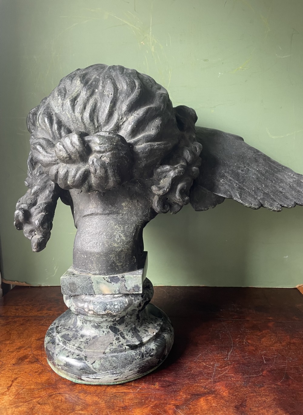 A 19th-century verdigris bronze head study of Hypnos featuring a winged temple, mounted on a round variegated green marble base. View XXIII