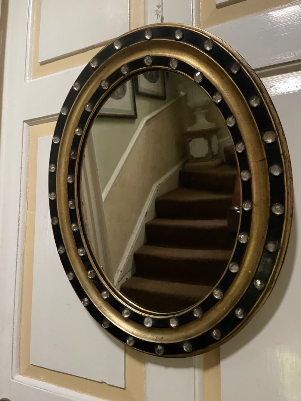 Mid C19th Irish oval mirror in ebonised and parcel-gilt moulded profile frame set with a double band of facetted cut-glass cabochons.  View II