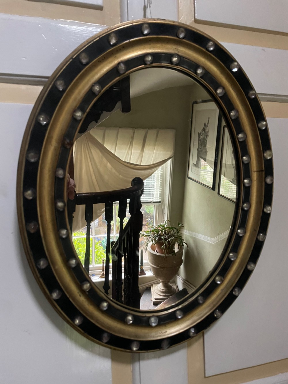 Mid C19th Irish oval mirror in ebonised and parcel-gilt moulded profile frame set with a double band of facetted cut-glass cabochons.  View IV