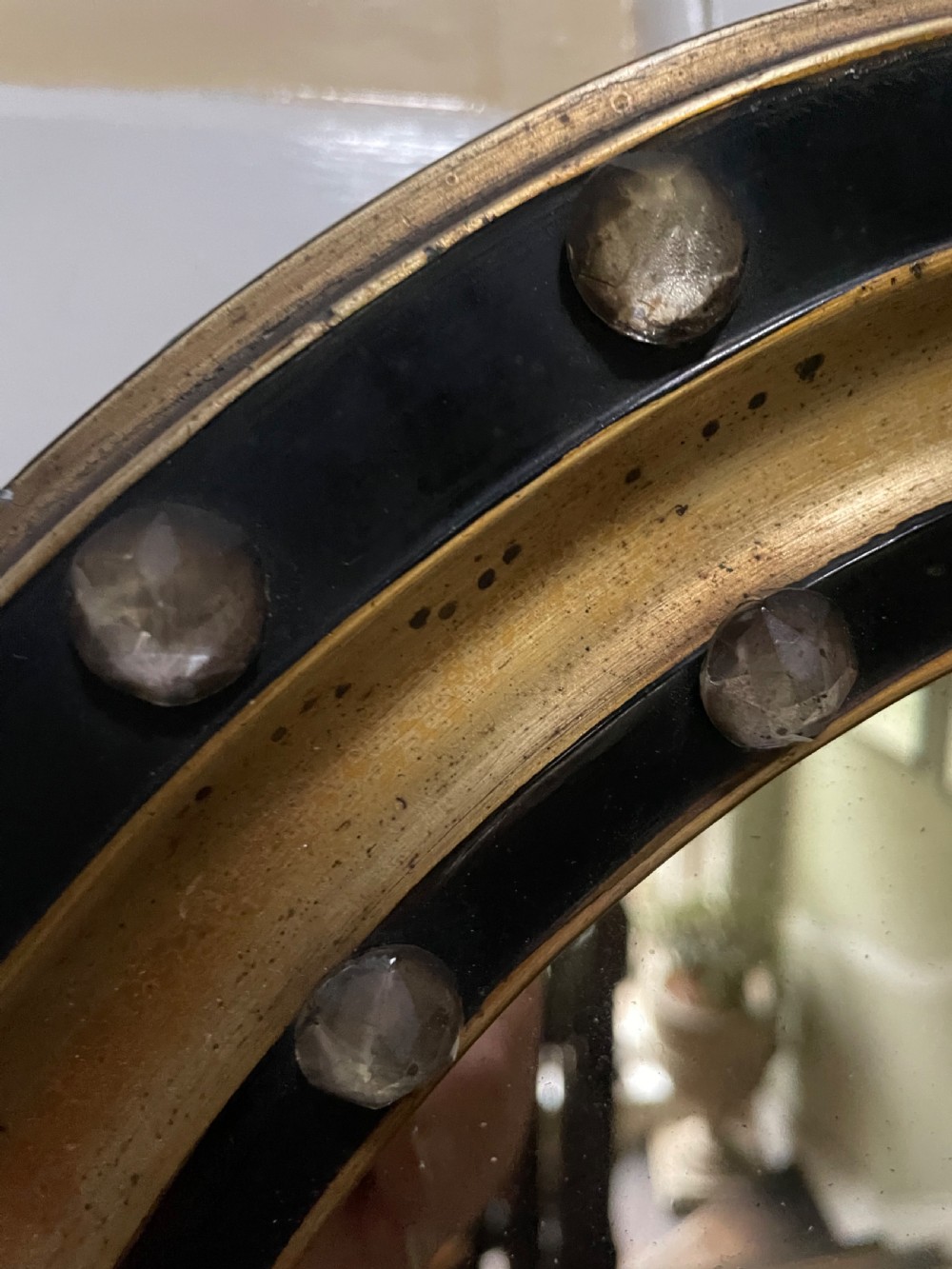 Mid C19th Irish oval mirror in ebonised and parcel-gilt moulded profile frame set with a double band of facetted cut-glass cabochons.  View V