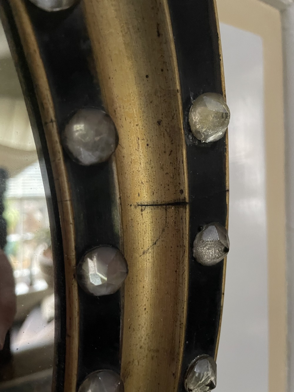 Mid C19th Irish oval mirror in ebonised and parcel-gilt moulded profile frame set with a double band of facetted cut-glass cabochons.  View IX