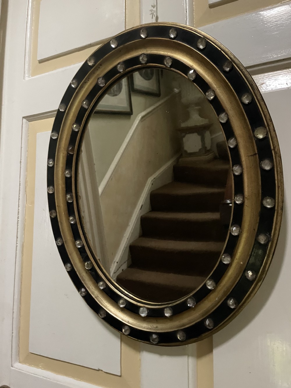 Mid C19th Irish oval mirror in ebonised and parcel-gilt moulded profile frame set with a double band of facetted cut-glass cabochons.  View XV