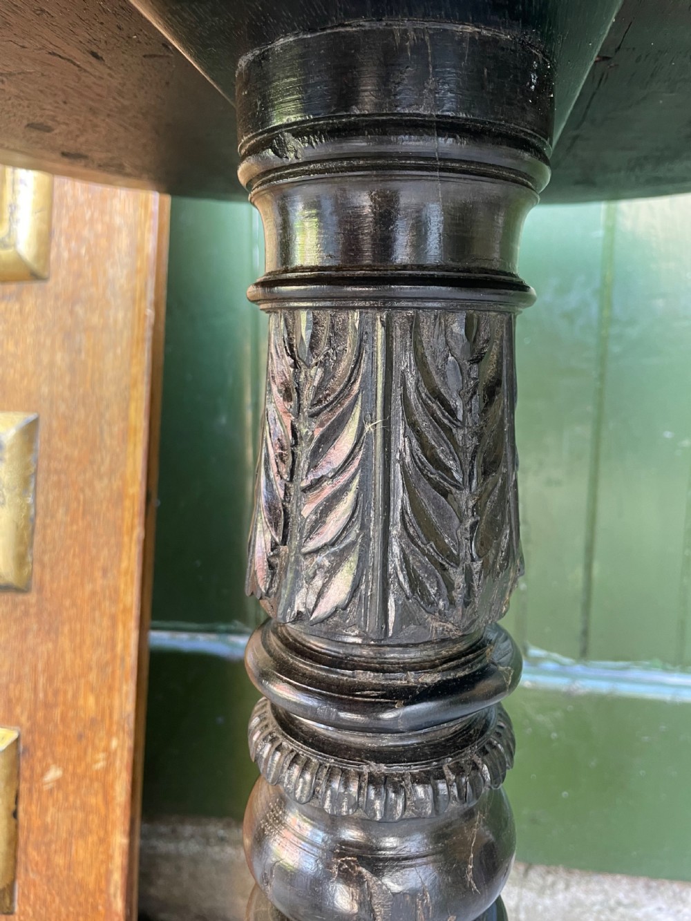 A 19th-century Anglo-Indian pedestal table featuring a carved ebony base and a starburst inlaid specimen wood top. View X