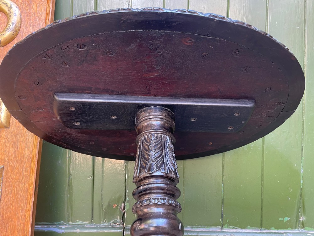 A 19th-century Anglo-Indian pedestal table featuring a carved ebony base and a starburst inlaid specimen wood top. View XVIII