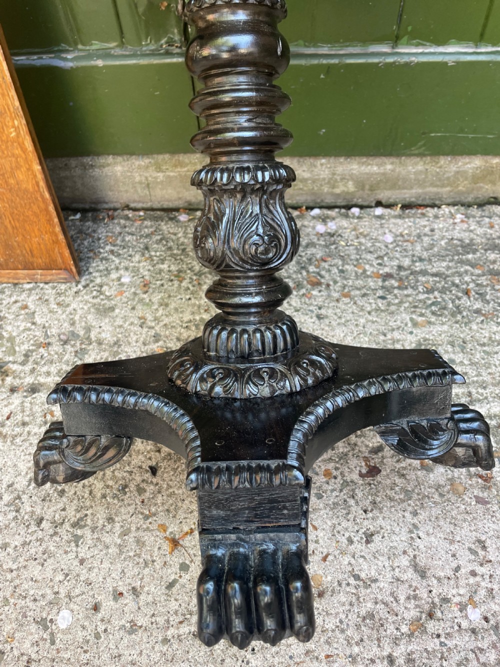 A 19th-century Anglo-Indian pedestal table featuring a carved ebony base and a starburst inlaid specimen wood top. View XIX