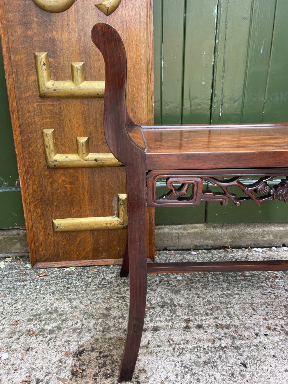 A late Qing Dynasty Chinese carved hardwood dressing stool featuring raised handles, openwork carved aprons, and square legs with stretchers. View VII