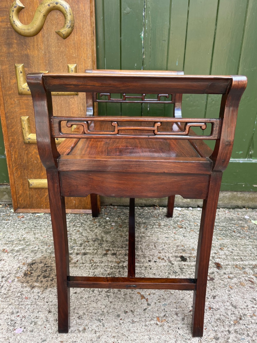 A late Qing Dynasty Chinese carved hardwood dressing stool featuring raised handles, openwork carved aprons, and square legs with stretchers. View VIII