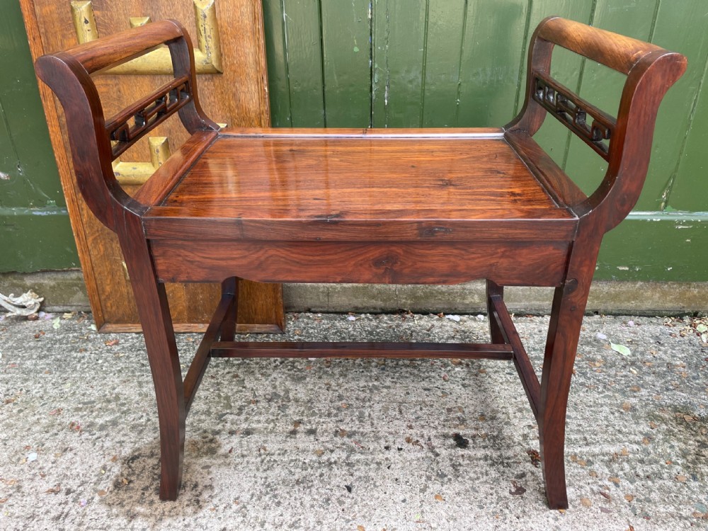 A late Qing Dynasty Chinese carved hardwood dressing stool featuring raised handles, openwork carved aprons, and square legs with stretchers. View IX
