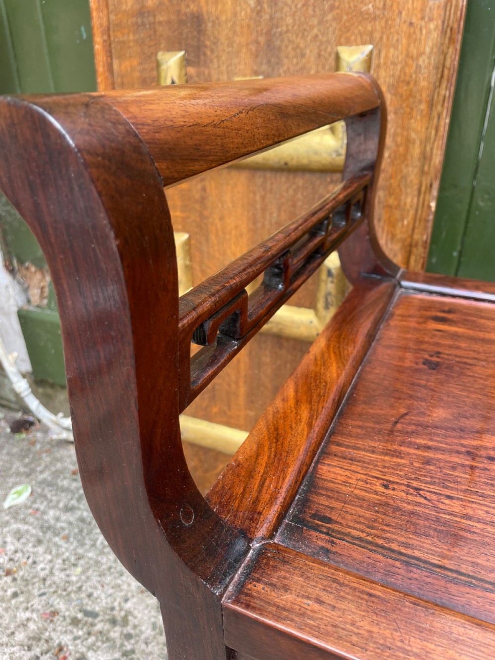 A late Qing Dynasty Chinese carved hardwood dressing stool featuring raised handles, openwork carved aprons, and square legs with stretchers. View XIII