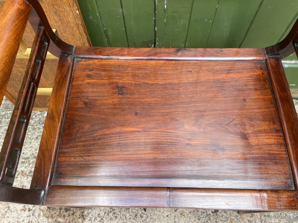 A late Qing Dynasty Chinese carved hardwood dressing stool featuring raised handles, openwork carved aprons, and square legs with stretchers. View XV