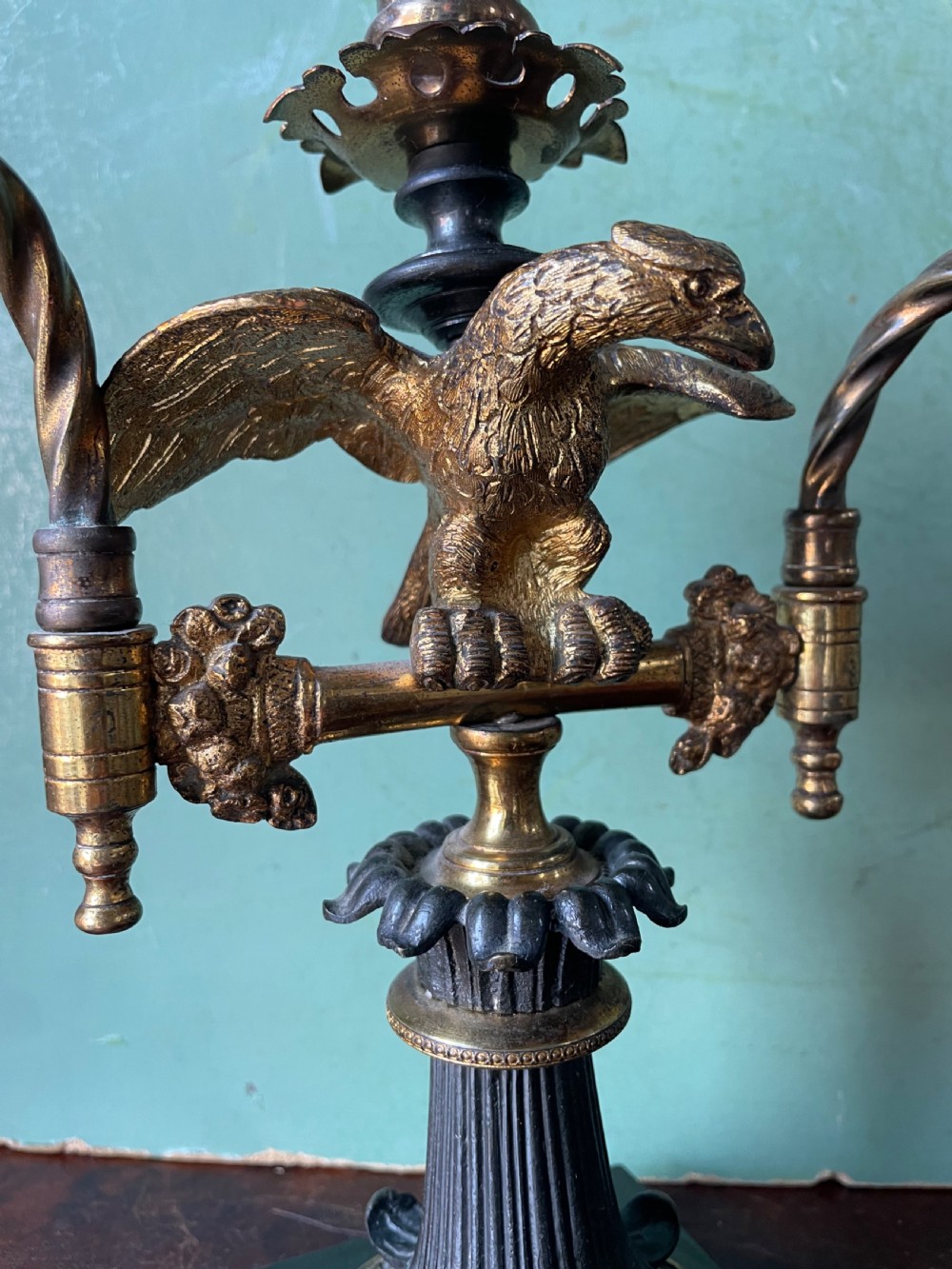 An early nineteenth-century Regency period three-light candelabra featuring adjustable swivelling arms, a central eagle figure perched above a fluted bronze column, and a square plinth base. View III