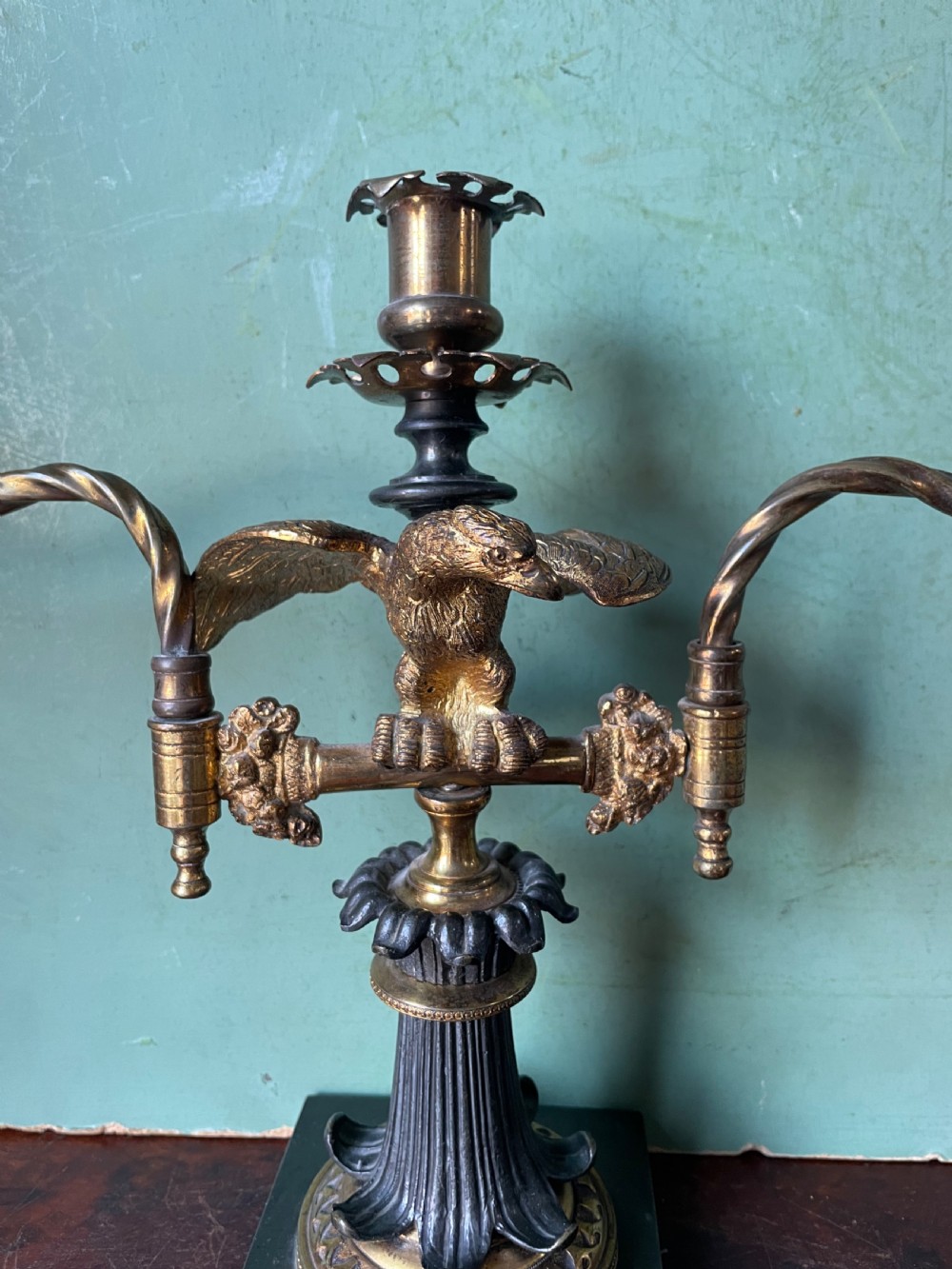 An early nineteenth-century Regency period three-light candelabra featuring adjustable swivelling arms, a central eagle figure perched above a fluted bronze column, and a square plinth base. View VI