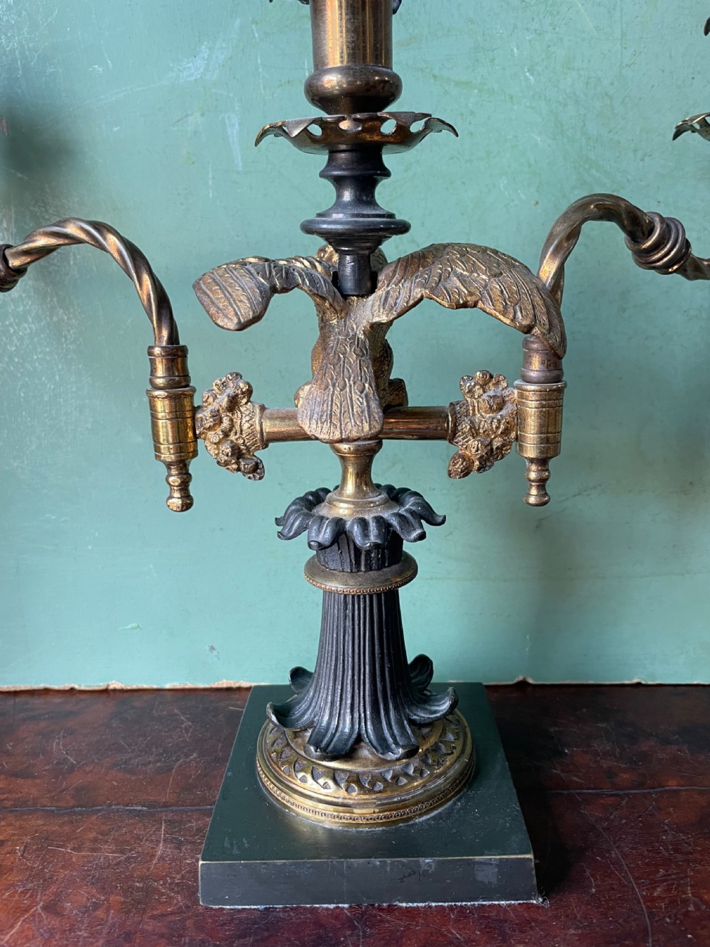 An early nineteenth-century Regency period three-light candelabra featuring adjustable swivelling arms, a central eagle figure perched above a fluted bronze column, and a square plinth base. View VII